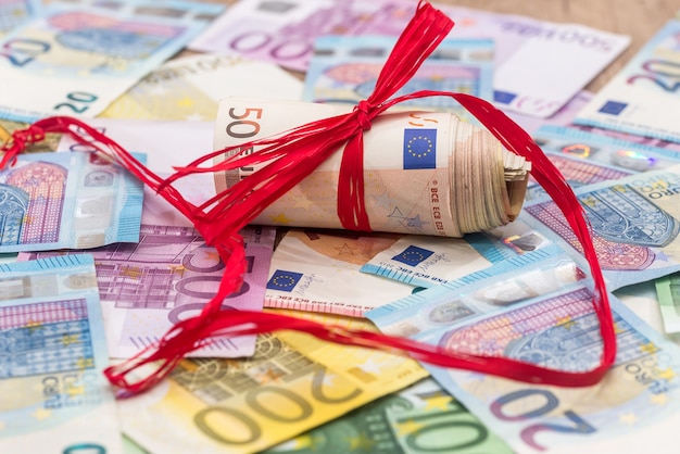 Large pile of euro money with red ribbon