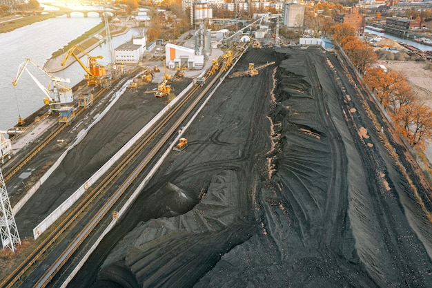 Large piles of coal, top view. Coal storage at the TPP, unloading and loading of coal by excavators and transport belts at the TPP warehouse. Aerial photography