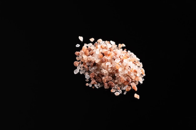 Large pink himalayan salt on black background, top view, empty space for text