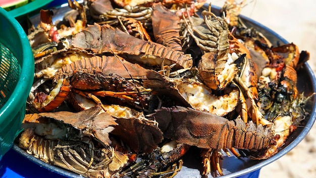 Large plate with a grilled seafood lobsters. BBQ exotic food on the beach. Selective focus.