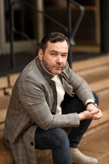 A large portrait of a man against the background of a city building. street style.