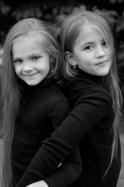 a large portrait of two blonde girls girlfriends with long hair in black sweatshirts