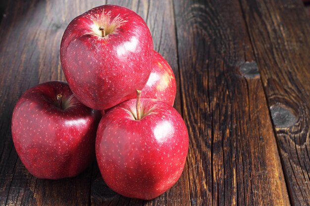 Large red apples on dark wooden table