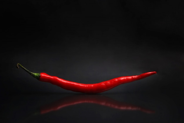 a large red chili isolated from a black background