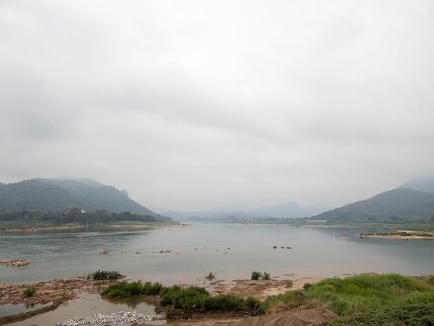 The large river with the long rapid along the high mountain on a rainy day