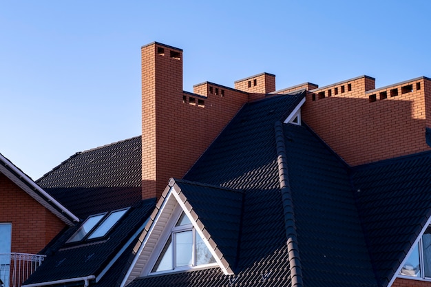 Large roof with brown metal tiles and chimneys.