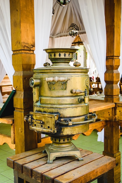 Large Russian brass samovar on a wooden table.