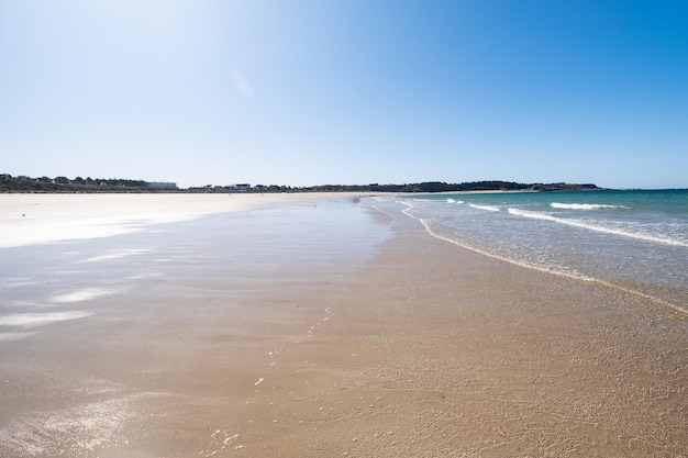 Large sandy beach in the town of Sables d'or les pins in Brittany at low tide in summer