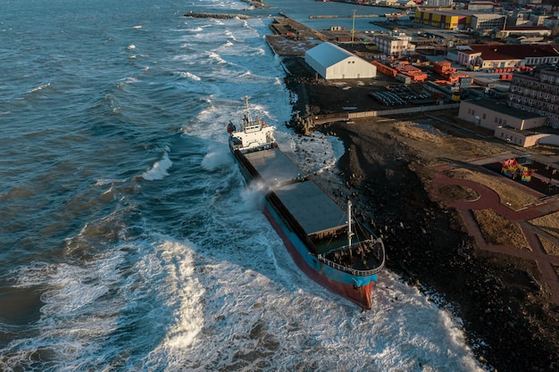 A large seagoing vessel dry cargo ship washed ashore during a strong storm wind and ran aground