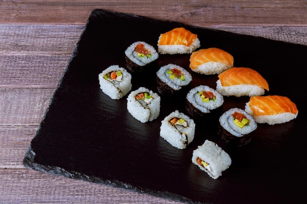 Large set of japanese rolls on a black stone plate sushi rolls japanese cuisine