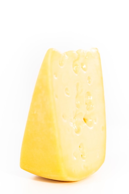 Large slice of semi soft part skim cheese on a white background.