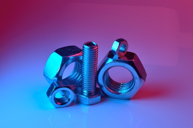 Large and small nuts and bolts highlighted in different colors on a light background