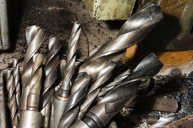 large spiral metal drills in a box in the workshop, drilling machine.