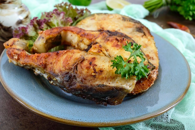 Large steaks of grilled fish with lettuce on a plate