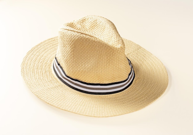 Large sun hat made of light straw for holidays on a light background