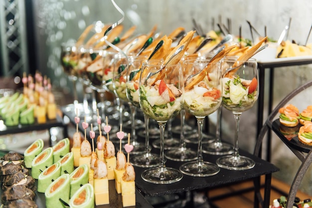 Large table with snacks of different types at a party with creative disco lighting