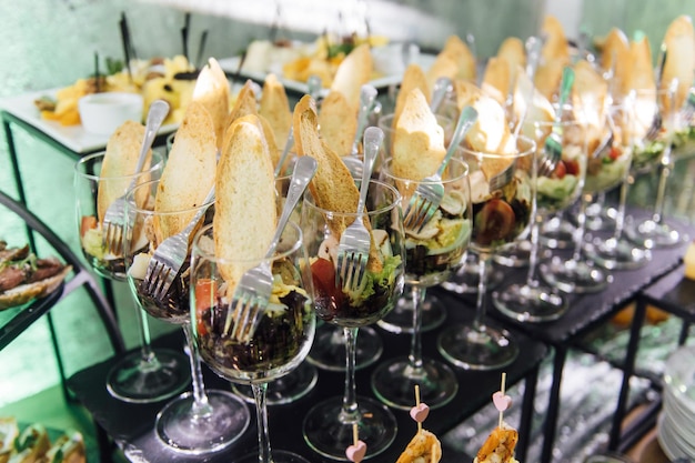 Large table with snacks of different types at a party with creative disco lighting