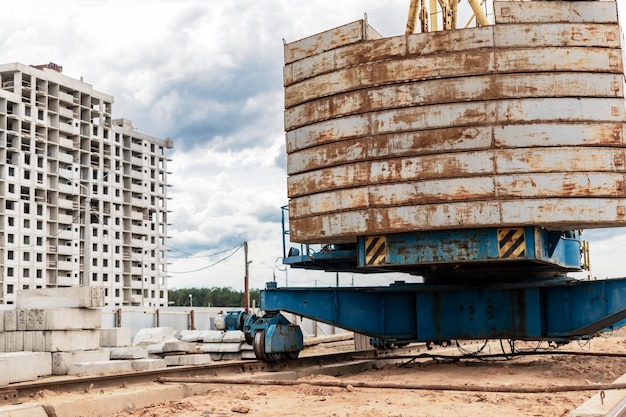 A large tower crane at a construction site against the backdrop of a modern monolithic house Modern housing construction industrial engineering Construction of mortgage housing