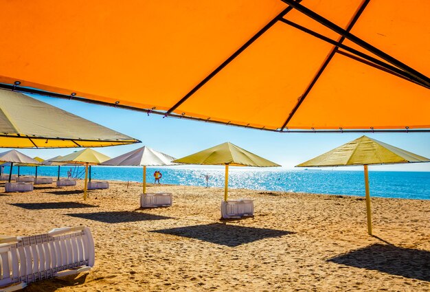 Large umbrellas from the sun on the beach near the sea.