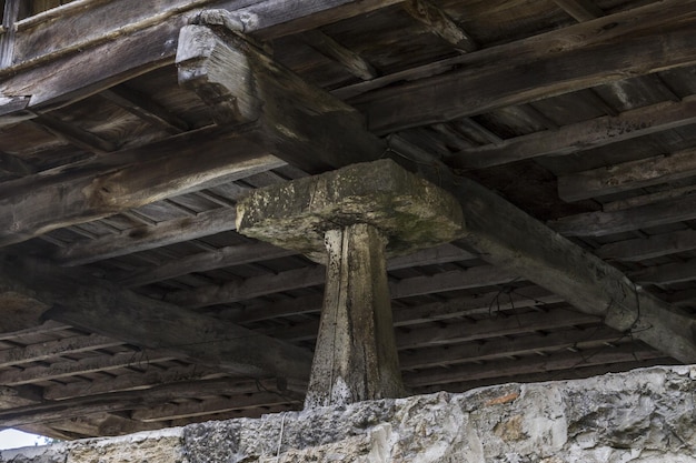 Large vertical megalith supporting an old wooden house