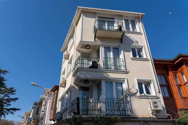 A large white building with balconies and a blue sky in the background