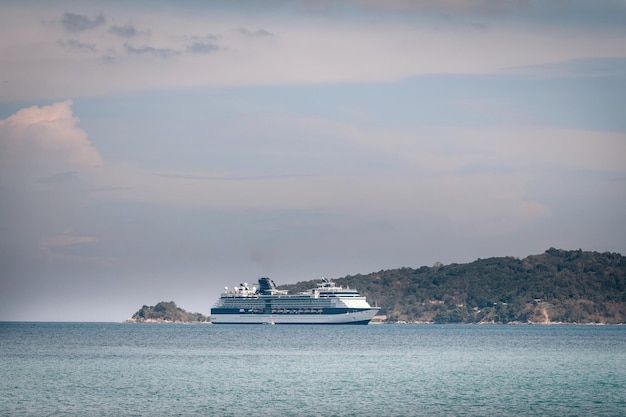 Large white cruise liner sails the turquoise Andaman sea; seascape; luxury tourism concept.