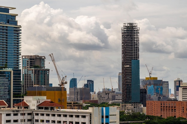 Large working construction cranes working on building highrise buildings in Bangkok Thailand