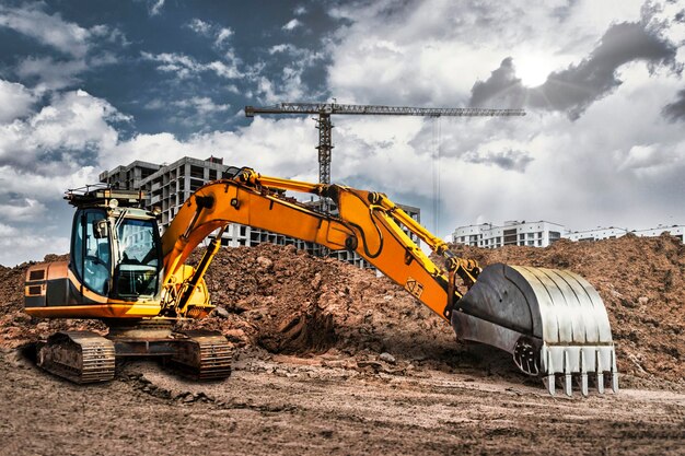 Photo a large yellow crawler excavator moving stone or soil in a quarry