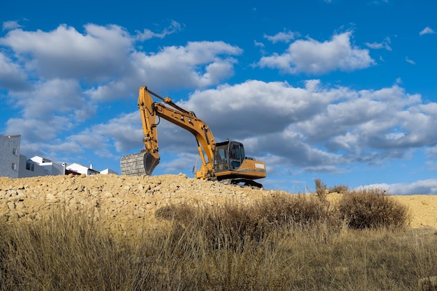 large yellow excavator working on the construction site moving earth