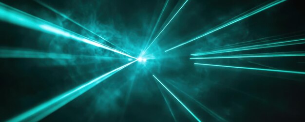 Photo laser beams of teal colored light on a black background