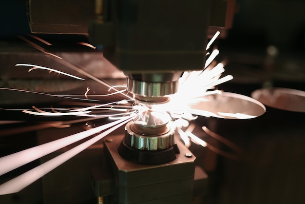 Laser cutting of metal sheet with sparks closeup. Modern industrial technology concept