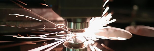 Laser cutting of metal sheet with sparks closeup modern industrial technology concept