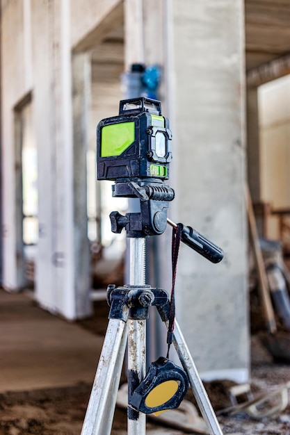 Laser level on a tripod at a construction site Closeup Taking measurements with a laser