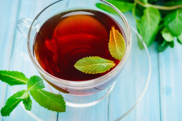 Lass cup of black tea or fresh mint leaves