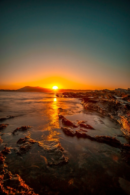 Last moments of the sun from the rocks of Hendaye on an orange sunset. France