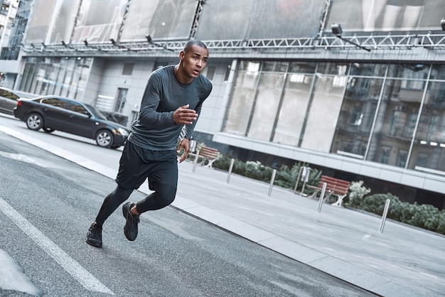 Latin american athlete running in city at morning