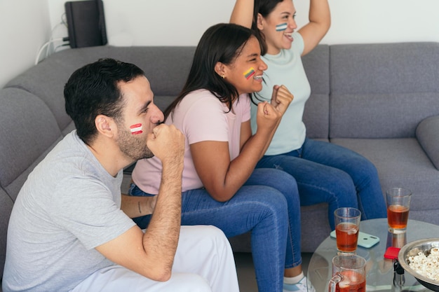 Latin American fans watching a soccer game at home on television