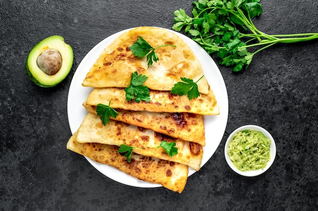 Latin American fried empanadas with avocado on a stone table