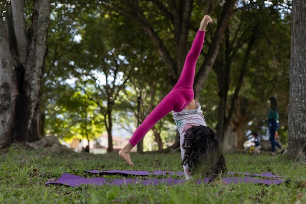 Latin American girl having fun in the park doing gymnastic exercises with dexterity