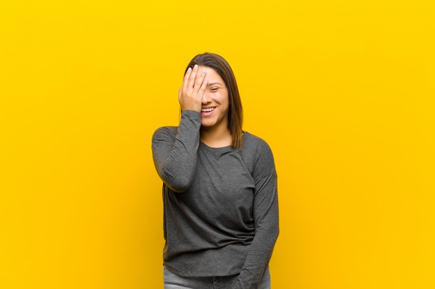 Latin american woman laughing and slapping forehead