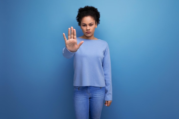 Latin brunette woman with wavy hair with gesture of denial and disagreement on background with copy