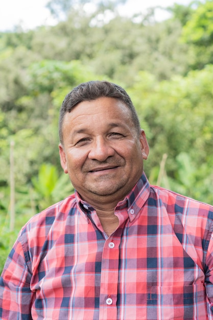 Latin farmer smiling while standing in the field