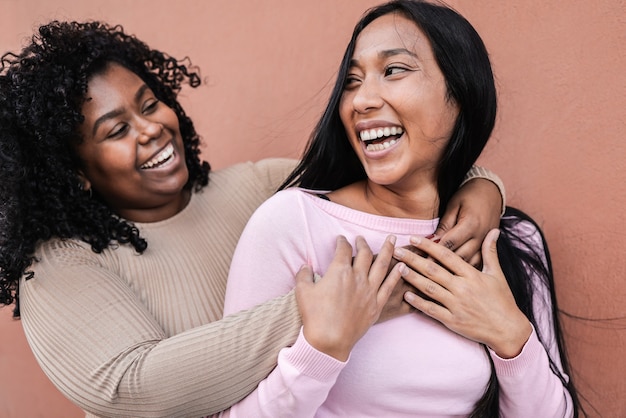 Latin girls having fun and hugging each other outdoor - Concept of happiness and friendship - Focus on right young woman eye