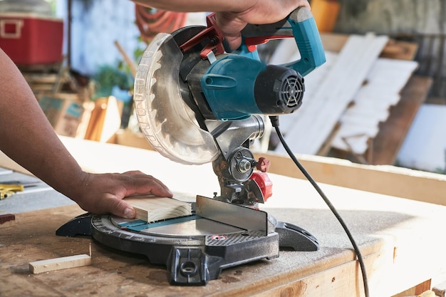 Photo latin man cutting wood with miter saw in cabinet shop