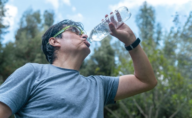 Latin man drinking water in a forest