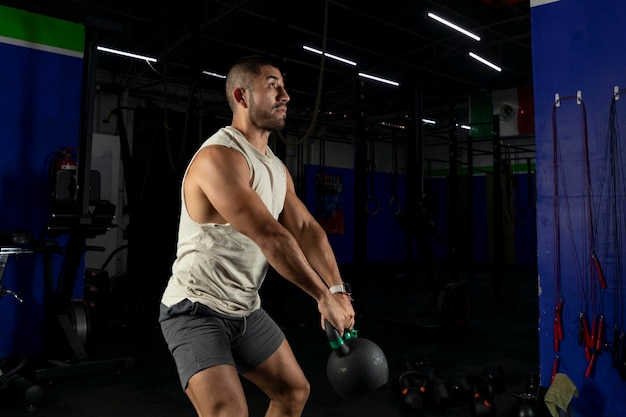 Latin man exercising with a kettlebell in a gym