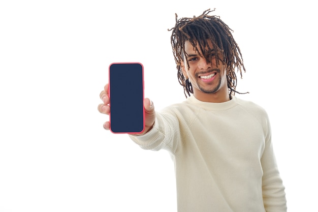 Latin man showing blank screen mobile phone to camera while standing on isolated background.