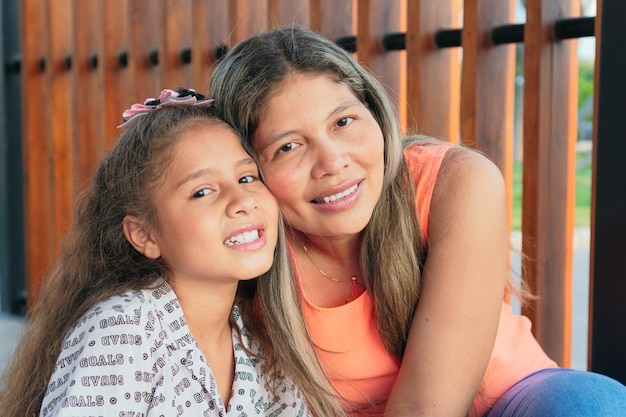 Latin mother and her daughter are happily playing together at the park