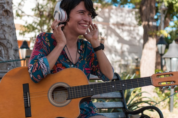 Latin Woman playing acoustic guitar at park