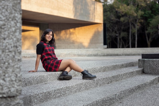 Latin woman sitting on the stairs of a museum in Mexico City with copy space